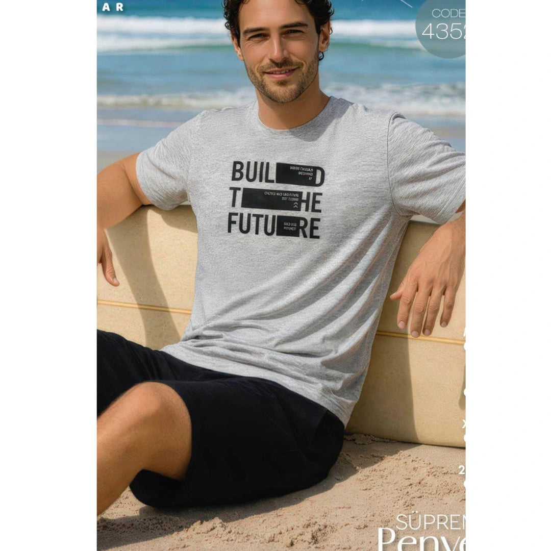 Man wearing a grey 100% cotton short-sleeve pyjama set with “Build the Future” print T-shirt and black shorts, breathable and comfortable men's summer sleepwear available at Aroma Garden Lebanon.