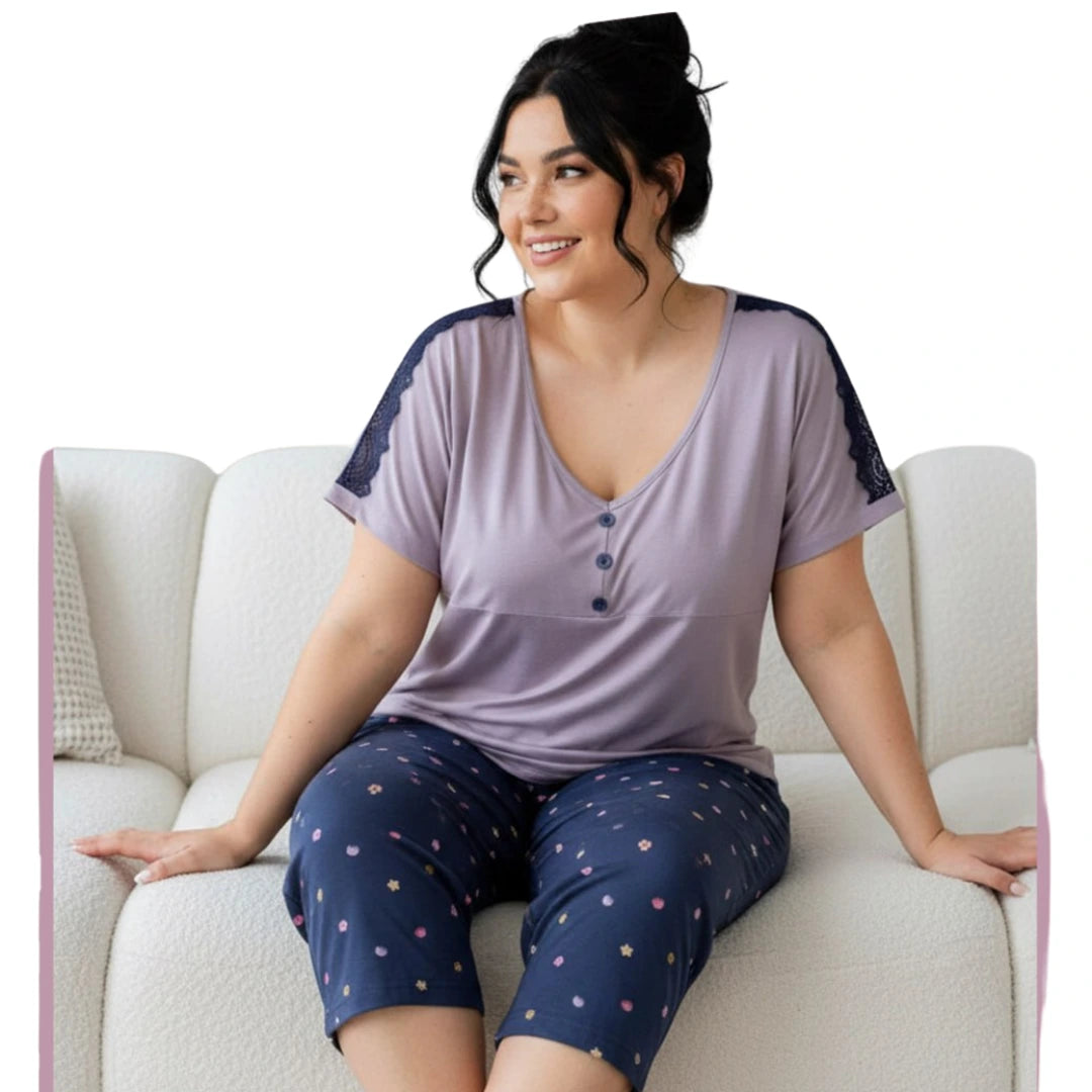 Plus size women's lavender short sleeve pyjama top with lace shoulder detail and navy printed capri pants, available in sizes 2XL, 3XL, 4XL, and 5XL.