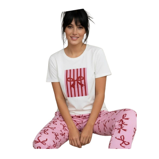 Woman wearing a white short-sleeve graphic T-shirt with matching pink ribbon-print cotton pyjama pants on a white background.