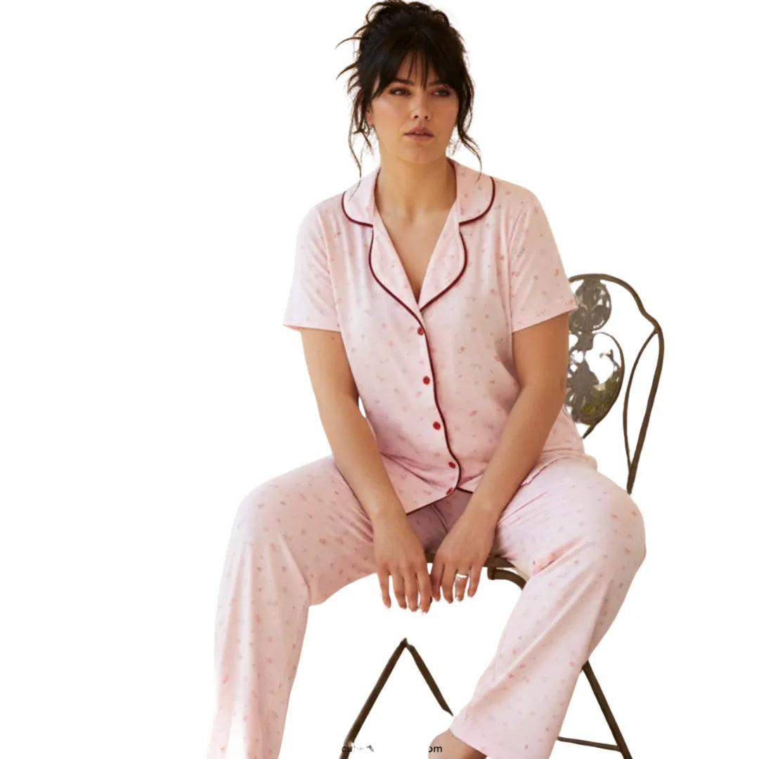 Women's light pink short-sleeve button-up pajama set with burgundy piping and matching full-length pants.